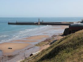 A beach with a pier and lighthouse at Rails End 