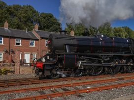 A steam locomotive beside brick buildings at Rails End in Whitby