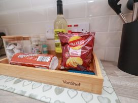 A kitchen with a bamboo tray containing biscuits and crisps at Rails End in Whitby