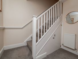 A staircase with a handrail and door at Rails End in Whitby