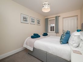 A bedroom with a bed and artworks on the wall at Rails End in Whitby