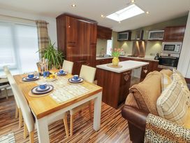 A kitchen with dining area and modern appliances at Jodene Lodge, Redwood 2 Bowness-On-Windermere