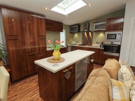 A kitchen with cabinets and appliances at Jodene Lodge, Redwood 2 Bowness-On-Windermere
