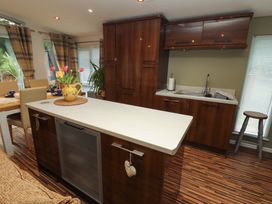 A kitchen with a sink and table at Jodene Lodge, Redwood 2 Bowness-On-Windermere