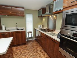 A kitchen with wooden cabinets and appliances at Jodene Lodge, Redwood 2 Bowness-On-Windermere