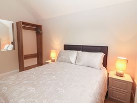 A bedroom with a bed, nightstand, and wardrobe at 17 ROOSKA, Lisdoonvarna, County Clare