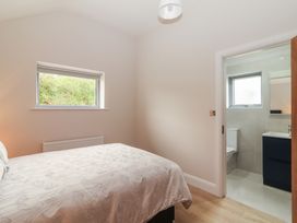 A bedroom with a bed and an en-suite bathroom at 17 ROOSKA in Lisdoonvarna, County Clare
