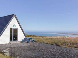 A cabin with a picnic table and ocean view at Cabin 2 Min Larach in Gortahawk