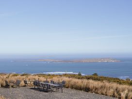 A seating area overlooking an island in the ocean at Cabin 2 Min Larach Gortahawk