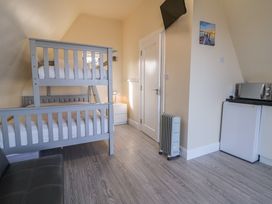 A bedroom with a bunk bed and kitchenette at Cabin 2 Min Larach in Magheraroarty near Gortahork, County Donegal