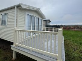 A mobile home with a deck and railing at Harbour Watch 22 Watchet