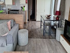 A living room with a sofa and dining table at Harbour Watch 22 Watchet