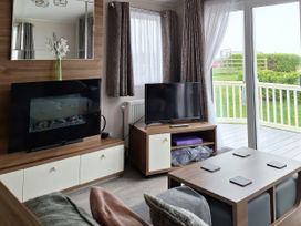 A living room with a television and coffee table at Harbour Watch 22 Watchet