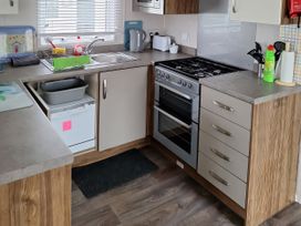 A kitchen with appliances and cabinets at Harbour Watch 22 Watchet