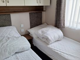 A bedroom with beds and a window at Harbour Watch 22 Watchet