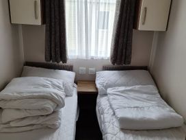 A bedroom with two beds and a window at Harbour Watch 22 Watchet