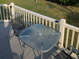 A table and chairs on a deck at Harbour Watch 22 Watchet