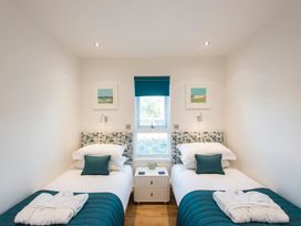 A bedroom with twin beds and a bedside table at Barbara in Portreath