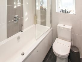 A bathroom with a bathtub, toilet, and shower at Barbara in Portreath