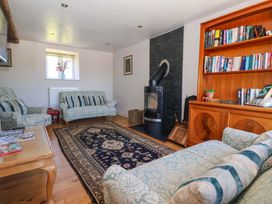 A living room with a stove and bookshelves at The Annexe at Dalby Carr