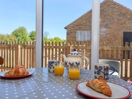 A dining table with croissants and drinks at The Annexe at Dalby Carr