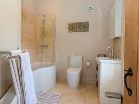 A bathroom with a bathtub, shower, toilet and sink at The Annexe at Dalby Carr 