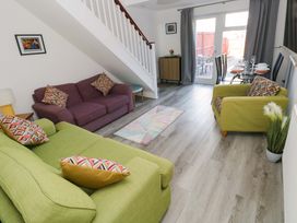 A living room with a sofa, armchairs, dining table, and window at The Gower Gateway Gowerton near Swansea