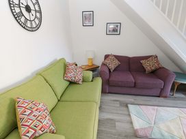 A living room with a green sofa and purple sofa at The Gower Gateway in Gowerton near Swansea