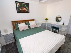 A bedroom with a bed and dresser at The Gower Gateway in Gowerton near Swansea