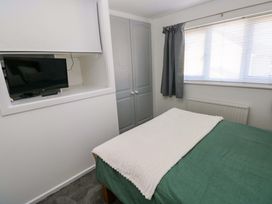 A bedroom with a bed, television, and wardrobe at The Gower Gateway in Gowerton near Swansea