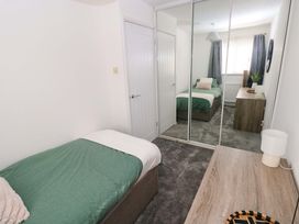 A bedroom with a bed, wardrobe, and desk at The Gower Gateway in Gowerton near Swansea
