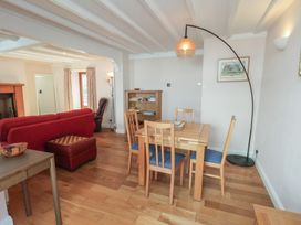 A living room with a sofa and dining area at Fleming Cottage