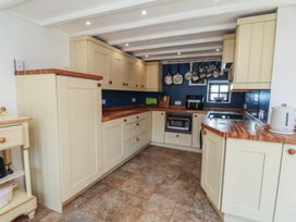 A kitchen with cabinets and appliances at Fleming Cottage