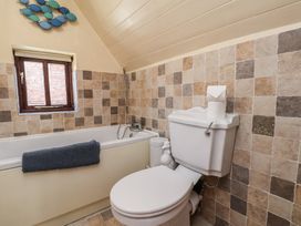 A bathroom with a bathtub and toilet at Fleming Cottage