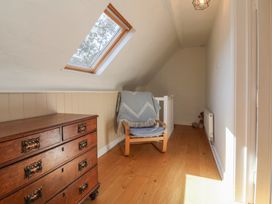 A hallway with a chair and chest of drawers at Fleming Cottage
