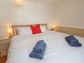 A bedroom with a bed and towels at Fleming Cottage