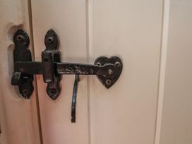 A door latch with a heart-shaped design at Fleming Cottage