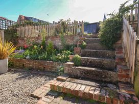 A garden with steps leading to a flower bed at Fleming Cottage