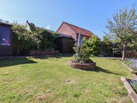 A garden with grass and trees at Fleming Cottage in 