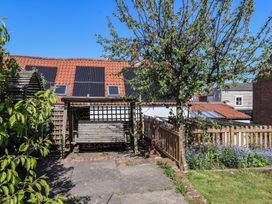 A garden with a swing and a tree at Fleming Cottage in 