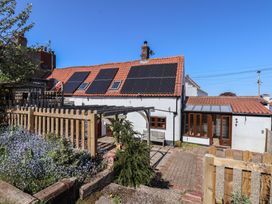 An outdoor area with a house and garden features at Fleming Cottage