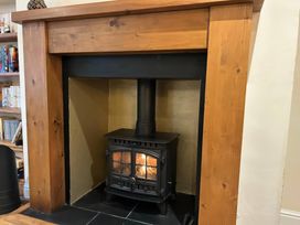 A fireplace with a wood stove in a living room at Fleming Cottage Hunmanby
