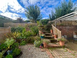 A garden with steps and flower pots at Fleming Cottage in Hunmanby