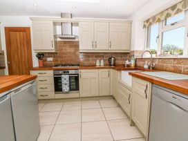 A kitchen with cabinets, cooker, sink, and refrigerator at Tinners Way in Helston