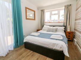 A bedroom with a bed and bedside table at Tinners Way in Helston