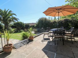 A garden with a table and chairs under an umbrella at Tinners Way in Helston