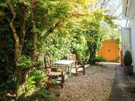 A garden with a table and chairs beside a yellow shed at Tinners Way Helston