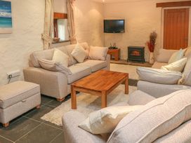 A living room with a sofa coffee table and television at Maerdy Cwtch Haverfordwest