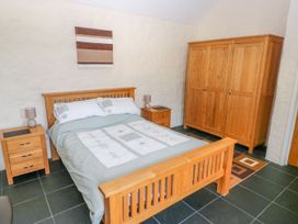 A bedroom with wooden furniture and a bed at Maerdy Cwtch in Haverfordwest