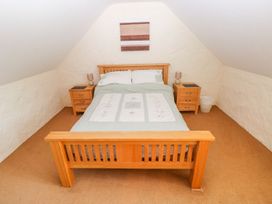 A bedroom with a bed and nightstands at Maerdy Cwtch in Haverfordwest